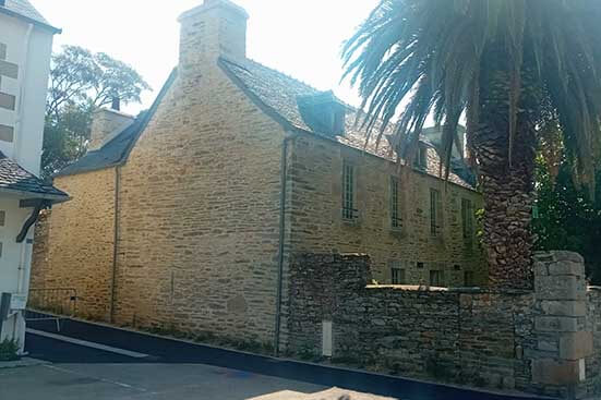 Photo d'une maison vue de profil en pierre avec une toiture en ardoise