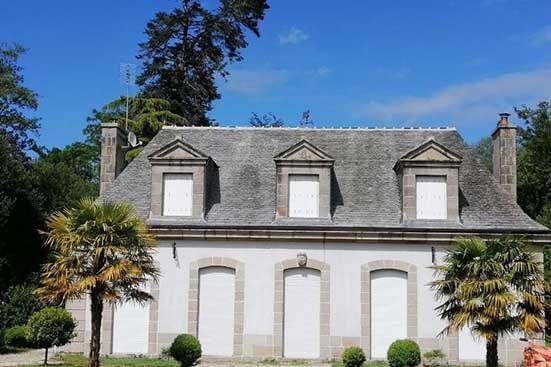 Photo d'une maison vue de face avec une toiture en ardoise